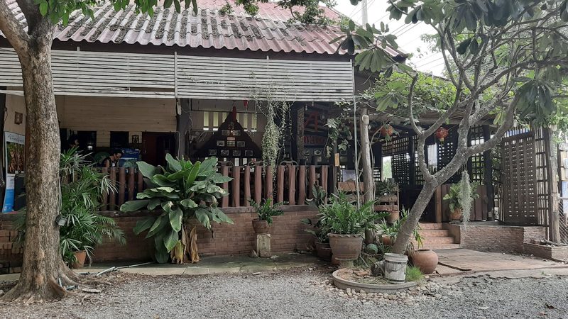 อาคารร้านไม้หลังร่มไม้และกระถางต้นไม้